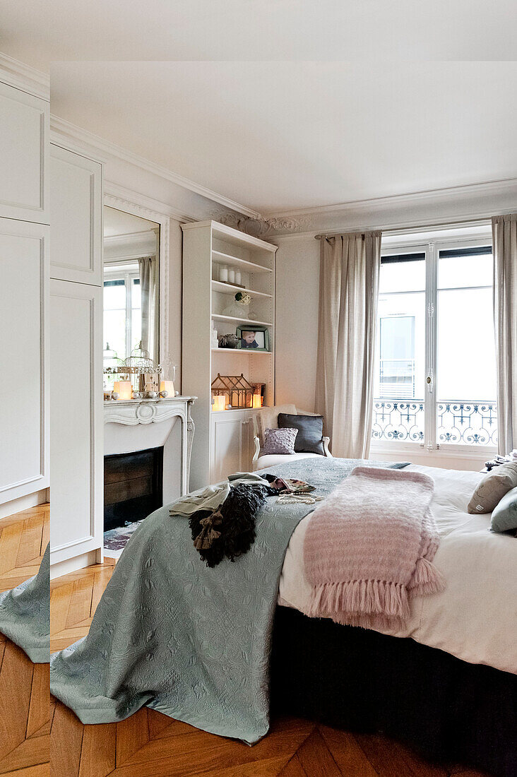 Light blue and pink blankets in bedroom of Paris apartment, France