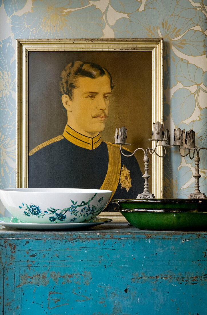 Military oil painting and vintage bowl on salvaged cabinet in London home, UK