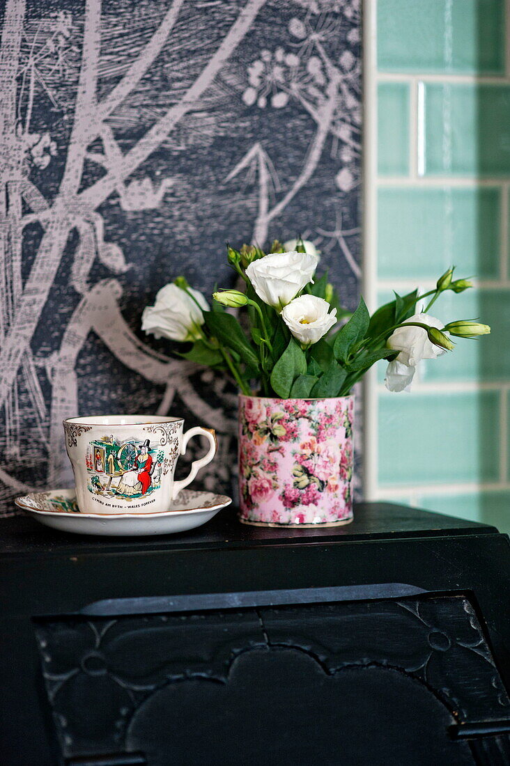 Schnittblumen mit alter Teetasse im Badezimmer des Familienhauses in Bovey Tracey, Devon, England, UK