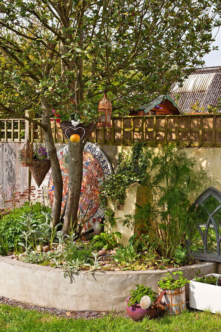 Gartenornamente mit Baum im Garten von Bovey Tracey, Devon, England, UK