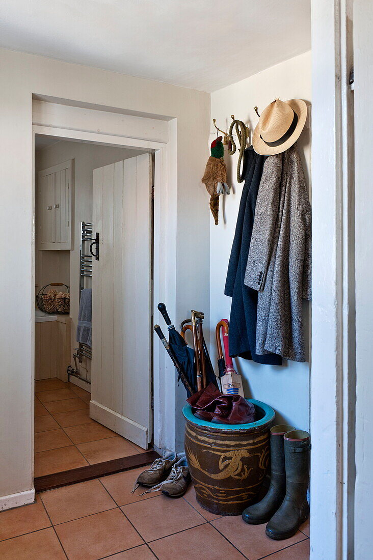 Umbrella stand and coat hooks at entrance to Suffolk farmhouse, England, UK
