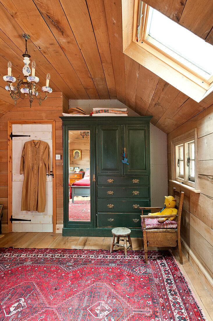 Green wardrobe and patterned rug in attic conversion of Essex home, England, UK