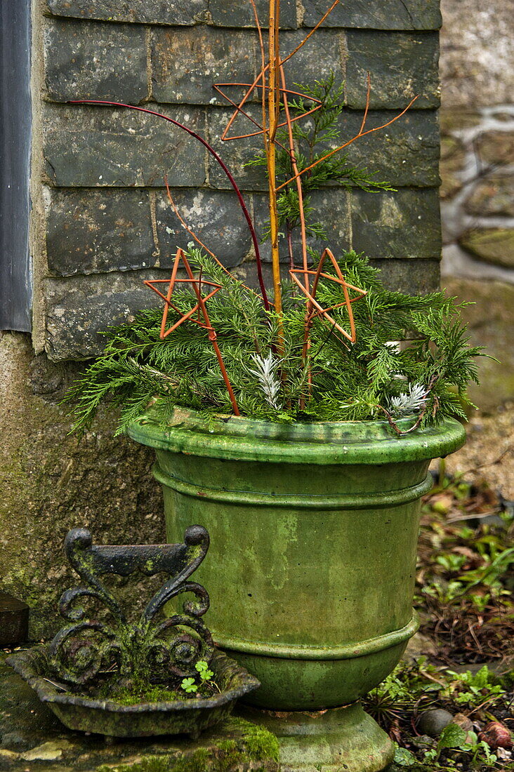 Weihnachtsdekoration und antiker Stiefelkratzer vor einem Bauernhaus in Cornwall, England, UK