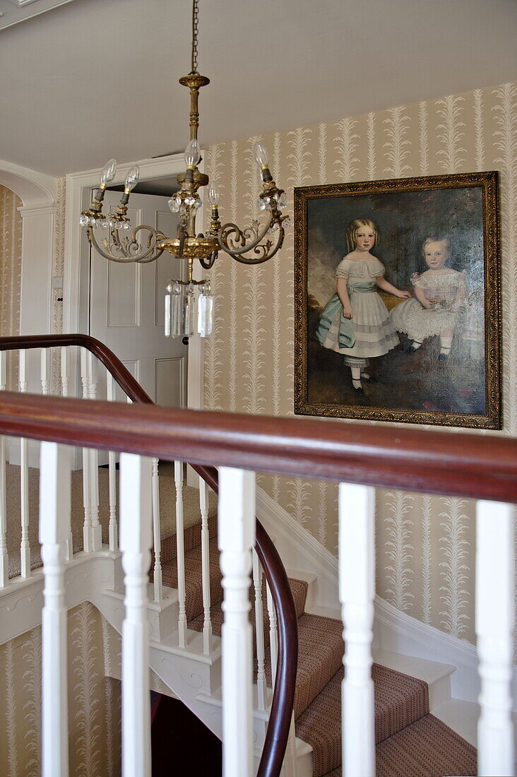 OIl painting and candelabra in staircase of Suffolk country house, England, UK
