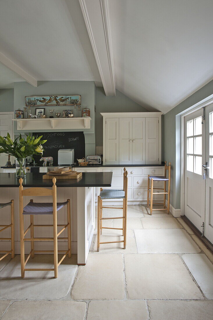 Wooden bar stools at breakfast bar in contemporary kitchen of Suffolk/Essex home, England, UK