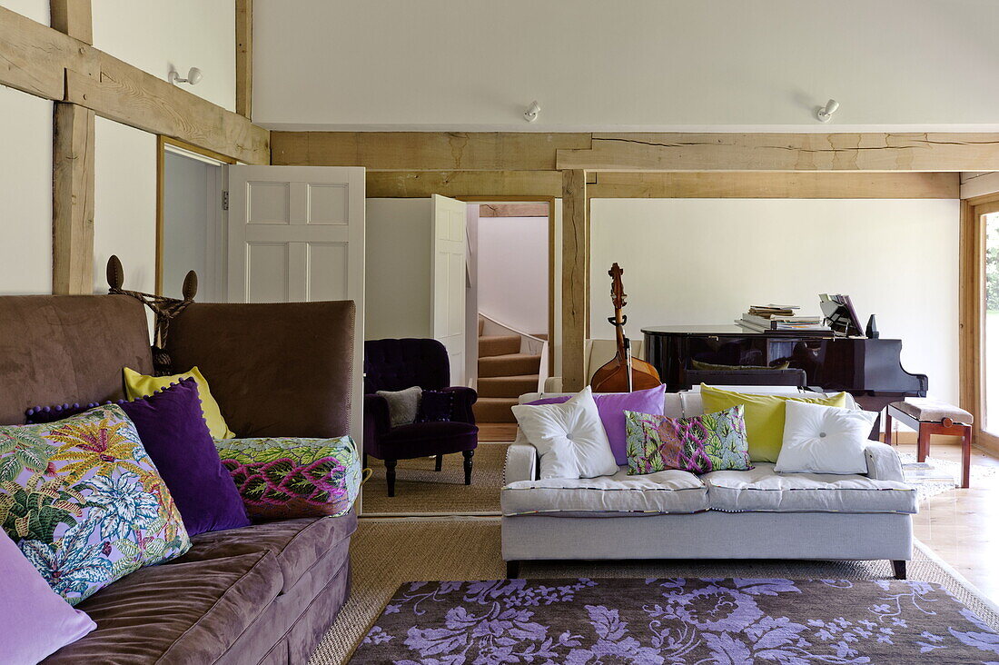 Contrasting sofas with floral patterned rug in open plan living room of contemporary Suffolk/Essex home, England, UK