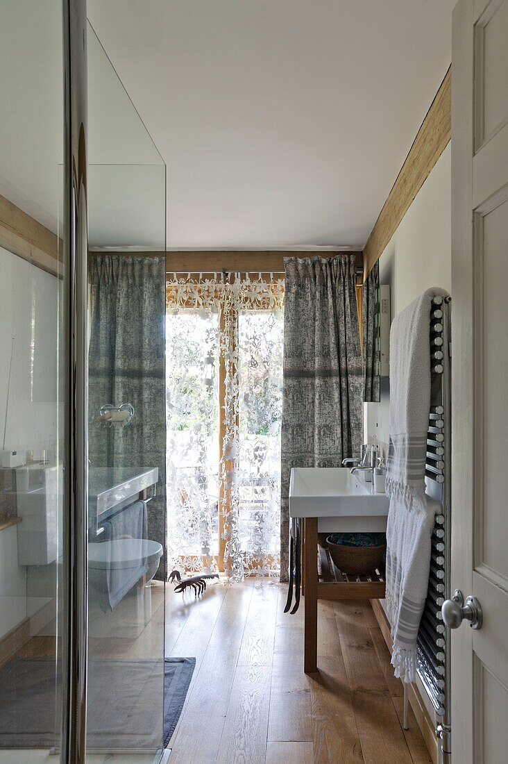 Glass shower screen and wash stand in bathroom of contemporary Suffolk/Essex home, England, UK