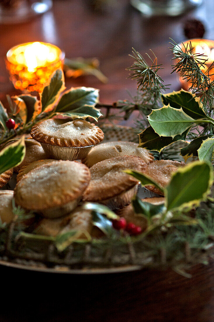 Mince Pies und Teelichter mit Stechpalme auf einem Tisch im Haus in Tregaron Wales UK