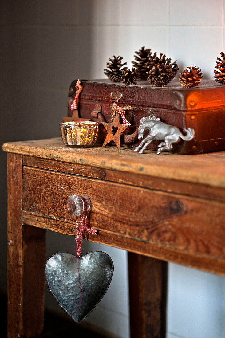 Vintage-Lederkoffer mit Weihnachtsschmuck und Herz auf hölzernem Beistelltisch in einem Haus in Tregaron Wales UK