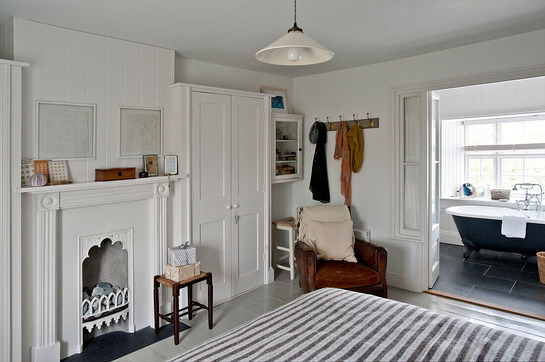 Ensuite bathroom to bedroom with brown leather armchair in Crantock home Cornwall England UK