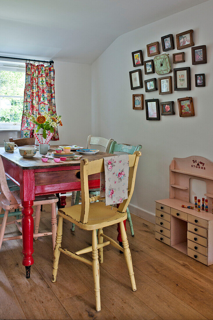 Framed artwork with painted kitchen table and chairs in Cambridge cottage England UK