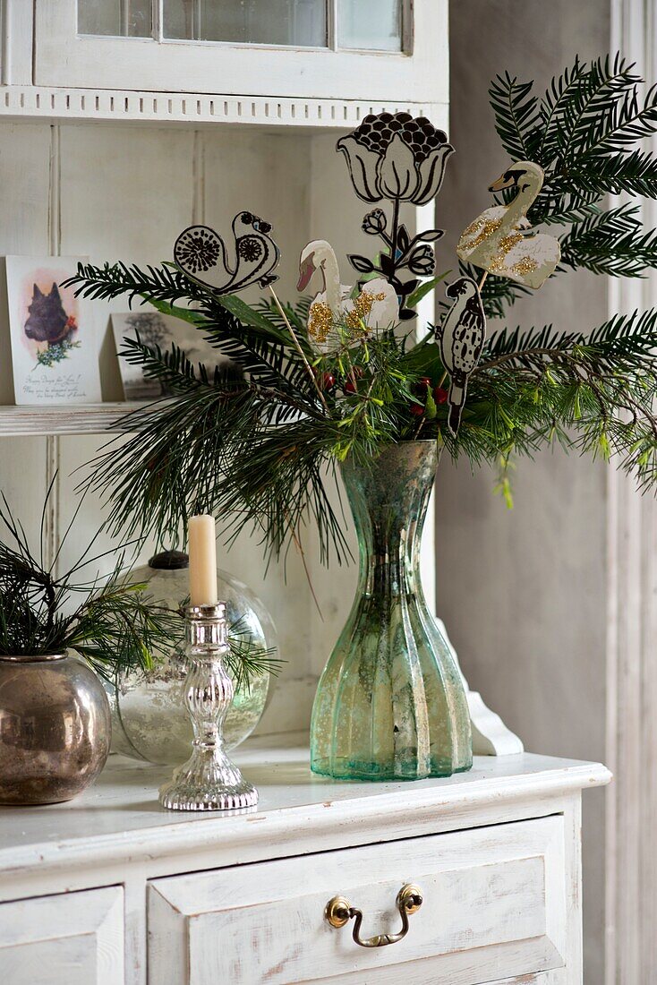 Cut flowers with silver candlestick on kitchen dresser in London home England UK