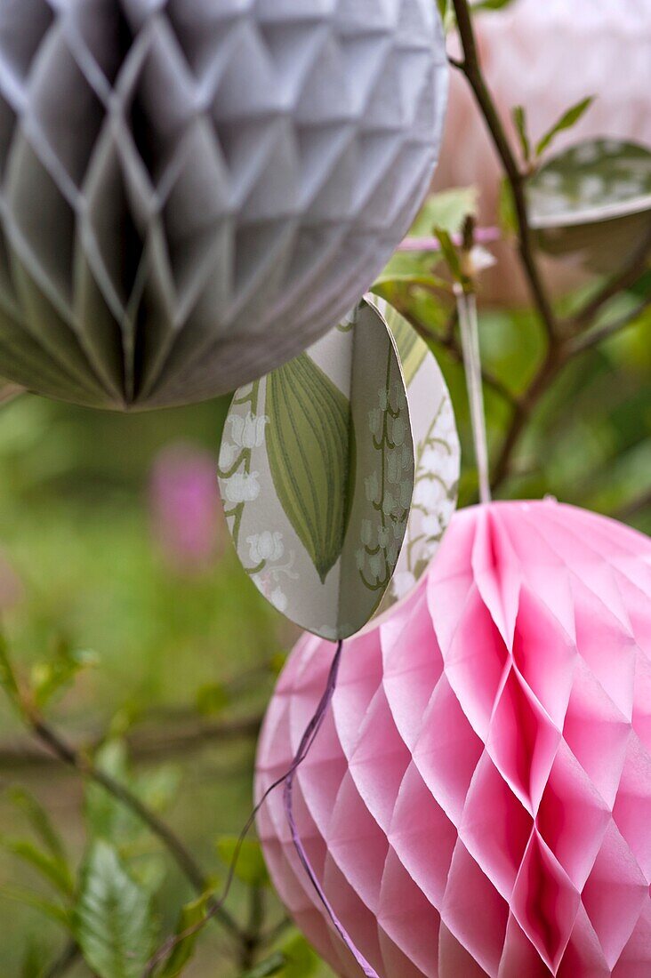 Paper cut Easter decorations hang in Magnolia tree Sussex garden UK