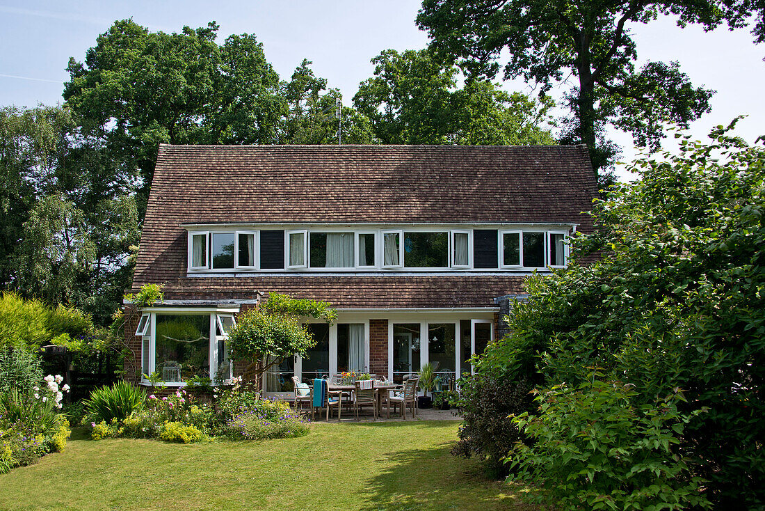 Lawned patio exterior of two-storey detached East Grinstead house Sussex England UK