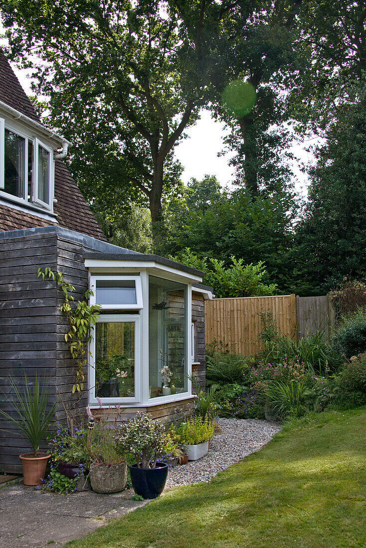 Gravel path and flowerpots at bay window of East Grinstead home Sussex England UK