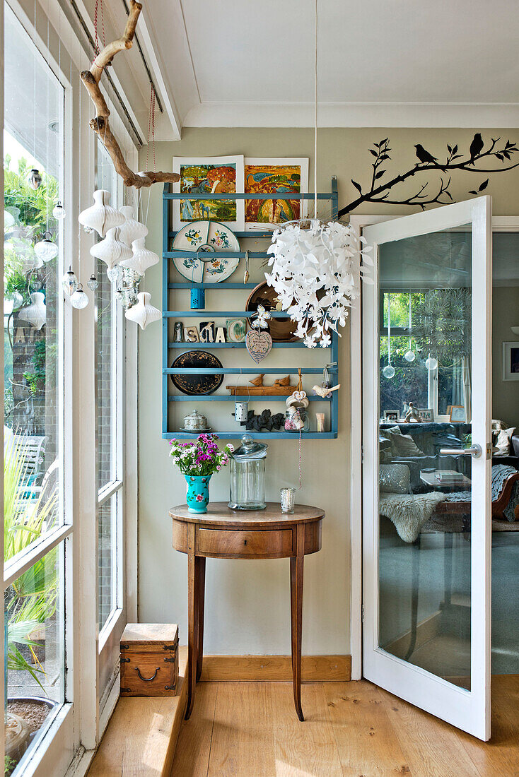 Beistelltisch aus Holz mit Glastür und Wandregal in einem Einfamilienhaus in East Grinstead, West Sussex, England