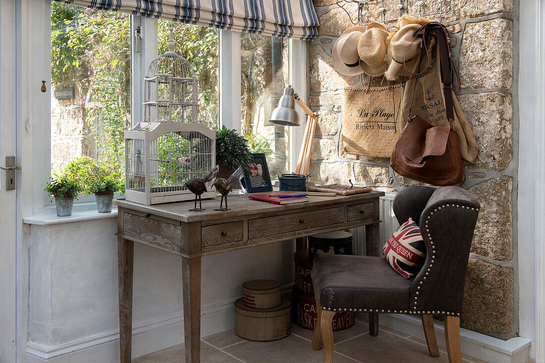 Brown chair at wooden desk with hat-rack in window of Penzance farmhouse Cornwall England UK