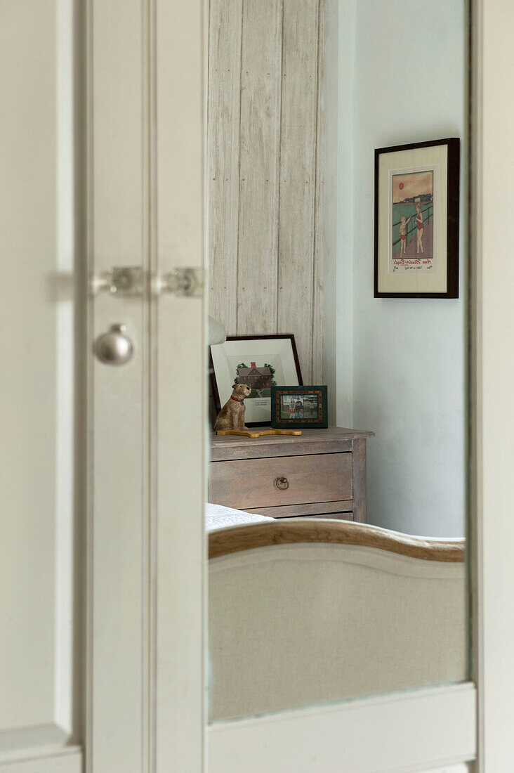 Bedside chest reflected in mirrored wardrobe in Penzance farmhouse Cornwall England UK