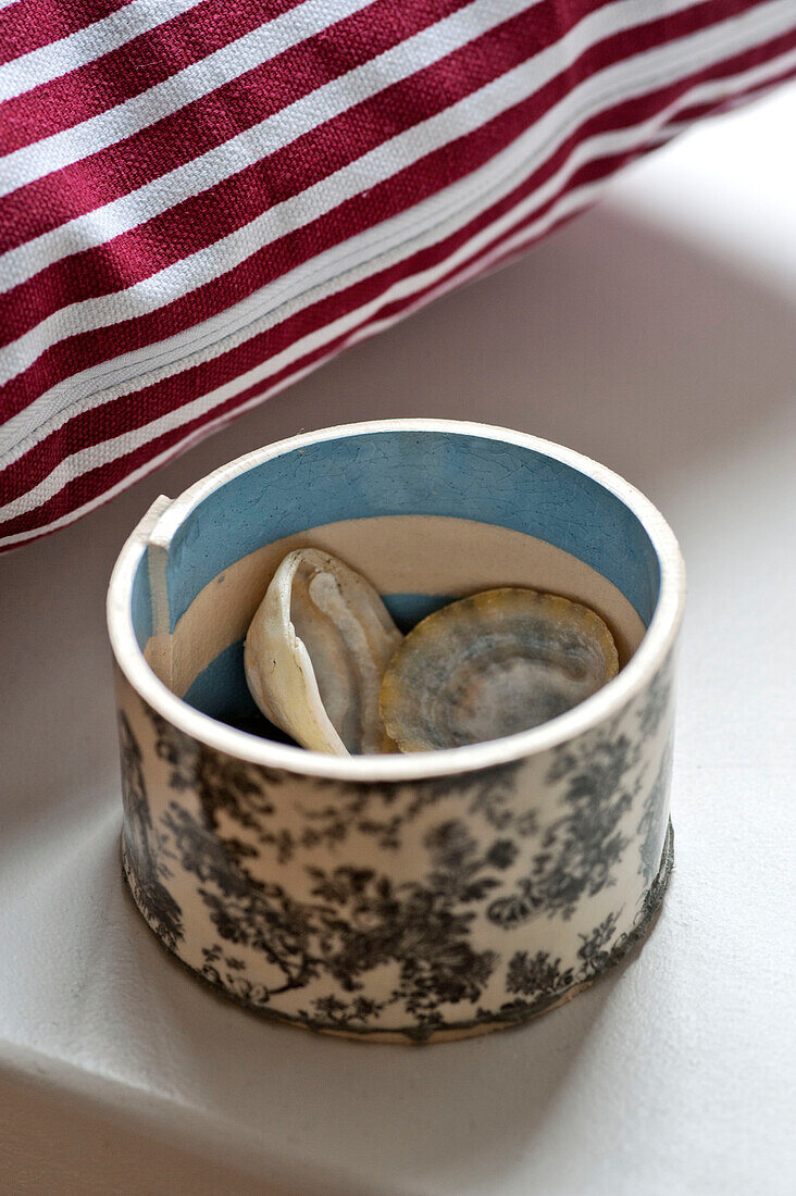 Seashells and striped cushion fabric in family townhouse Cornwall England UK