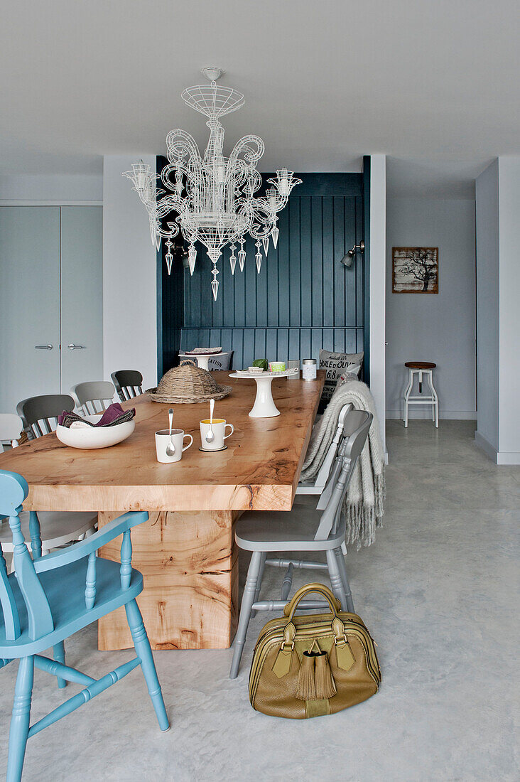 Leather bag and wooden dining table with chandelier in Lechlade home Gloucestershire England UK