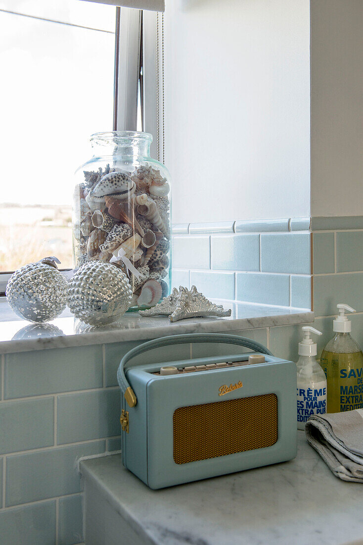 Muscheln und Kugeln auf der Fensterbank mit altem Radio im Haus in Penzance Cornwall UK