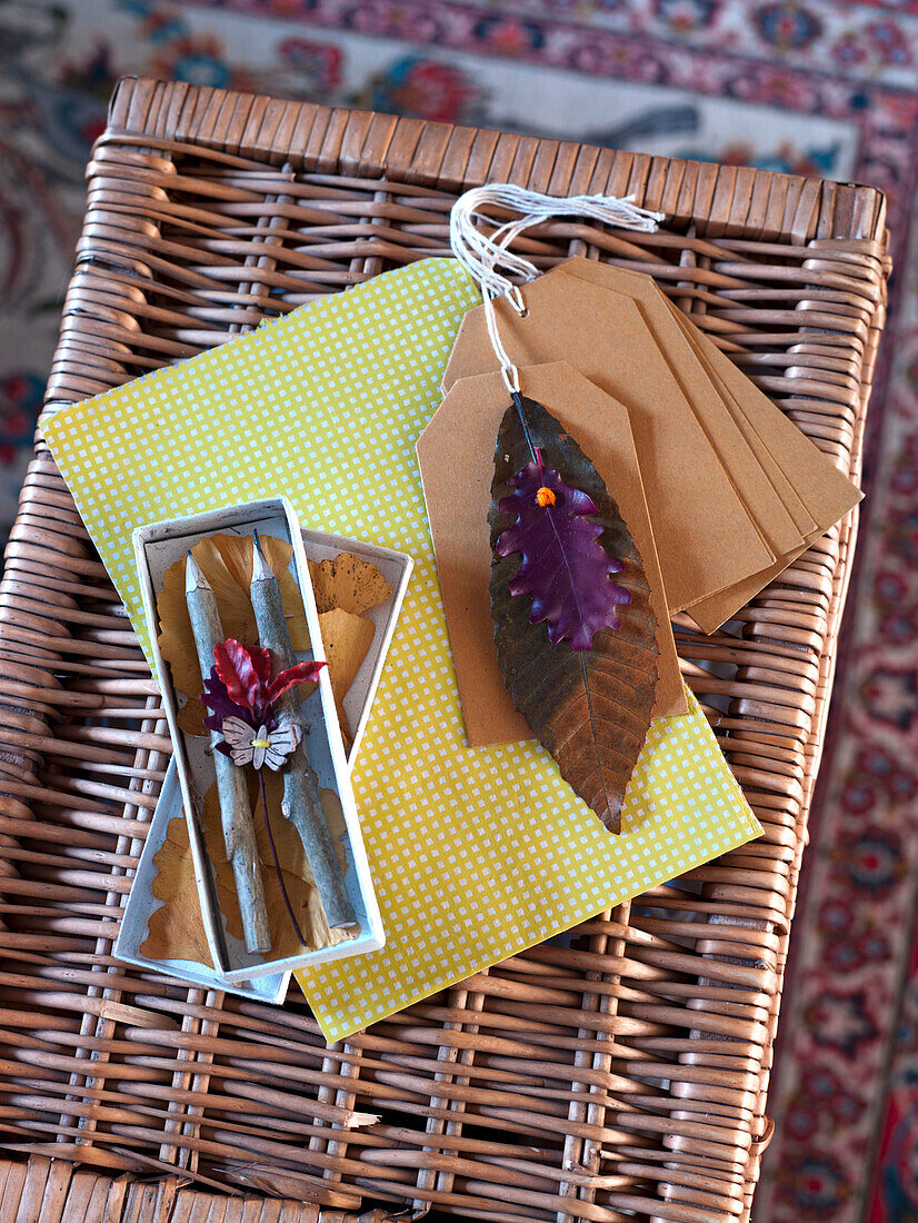 Pencils in gift box with tags and leaf decoration on wicker basket in UK home