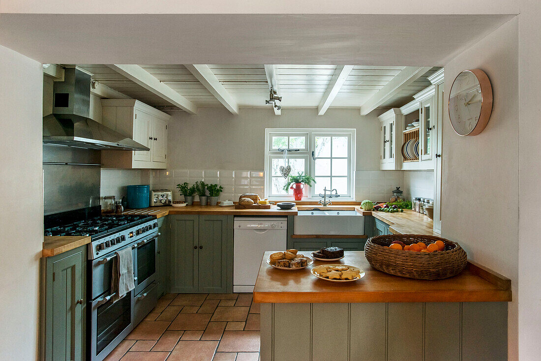 Farmhouse kitchen with repainted units and tiled floor in St Erth Cornwall UK