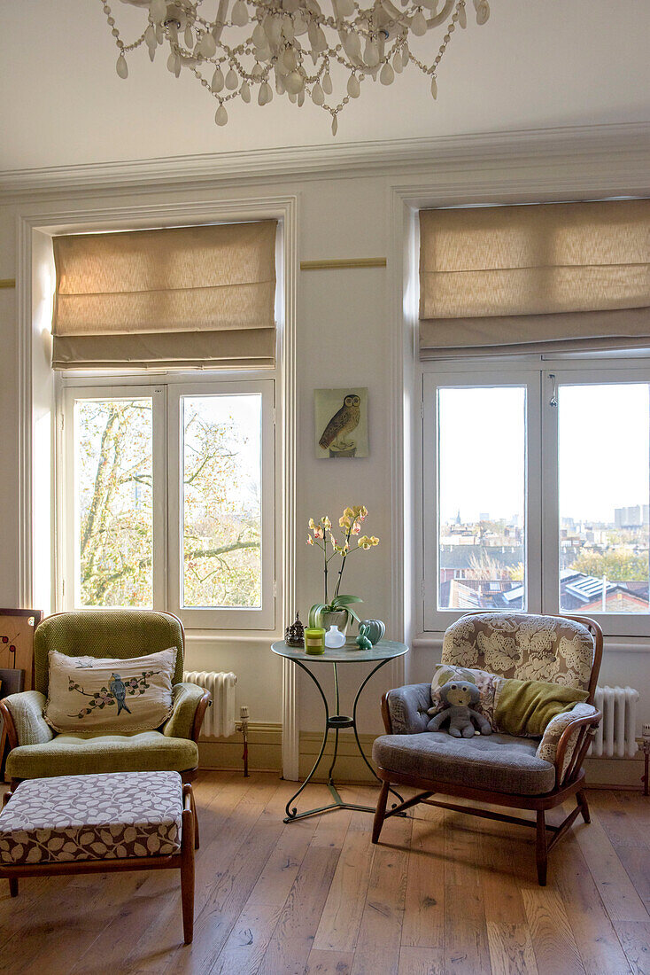 Vintage-Sessel und Fußbank mit Metallbeistelltisch in einem Fenster einer Londoner Wohnung UK