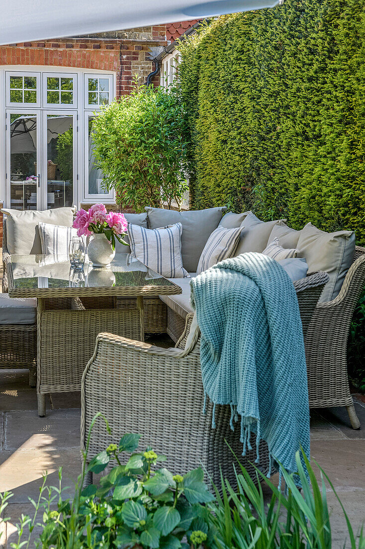 Terrassenmöbel aus Weidengeflecht im Garten eines Familienhauses in Godalming Surrey, Großbritannien