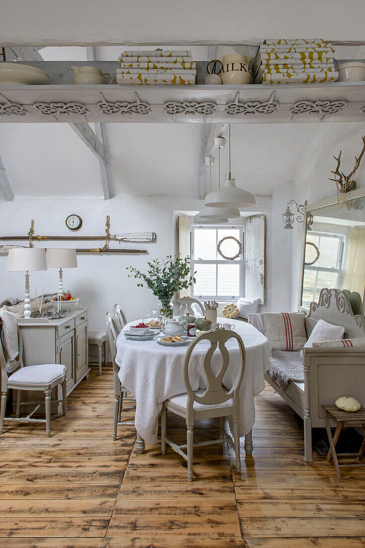 Esstisch und Stühle in einem Strandhaus in Marazion mit dekorativem Regal in Cornwall UK