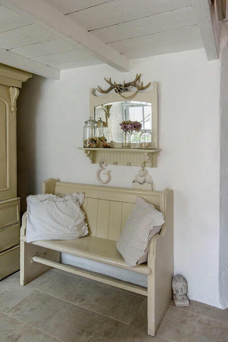 Cream bench seat and mirror in Marazion beach house Cornwall UK