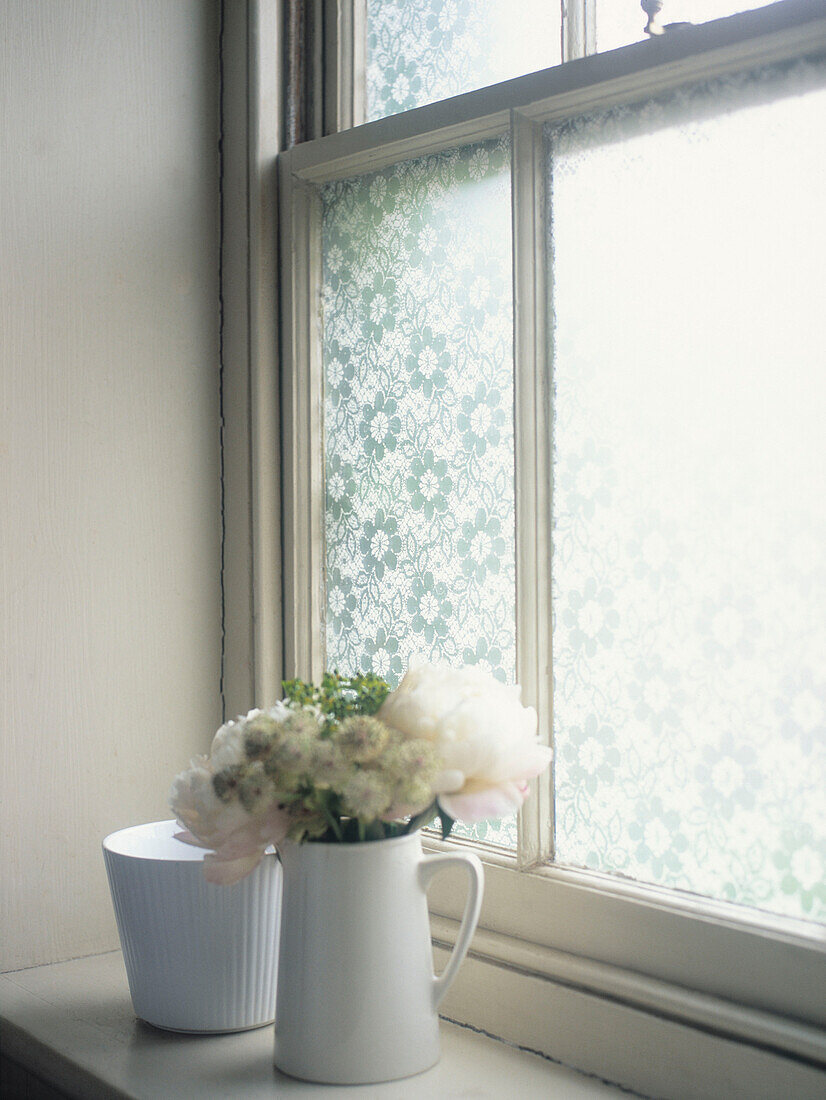 Schnittblumen auf der Fensterbank mit Milchglas