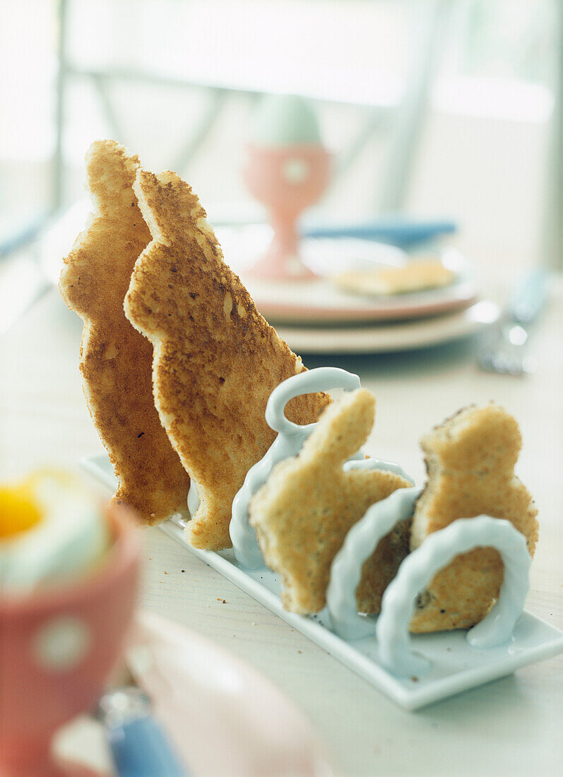 Osterfrühstück mit Toast in Hasenform in einem Toastständer