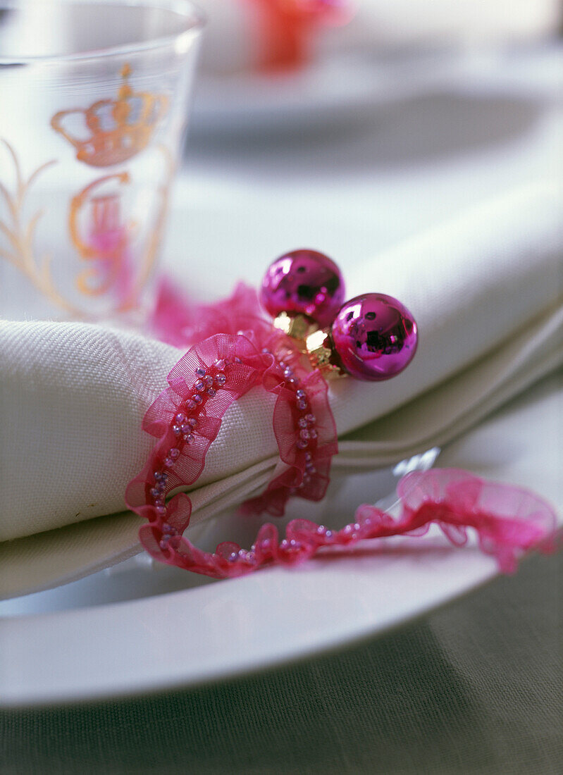 White napkins with pink bauble and ribbon