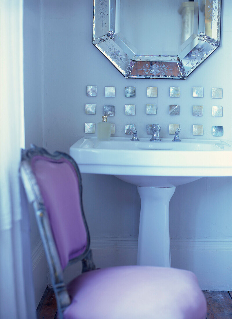 Bathroom sink with pretty mother of pearl mosaic tiles and Venetian glass mirror