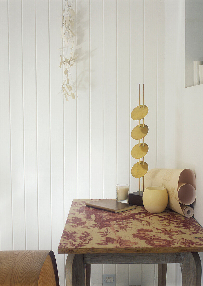 Sculpture vase and wallpaper's roll on the table