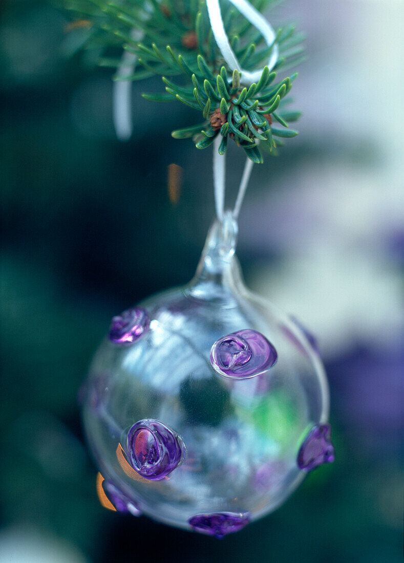 Handbemalte Glaskugel mit violetten Flecken am Weihnachtsbaum