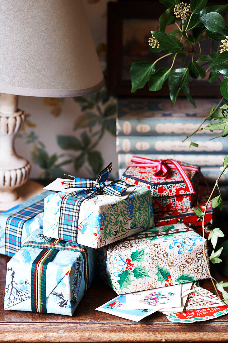 Gift wrapped Christmas presents with lamp in Shropshire cottage England UK