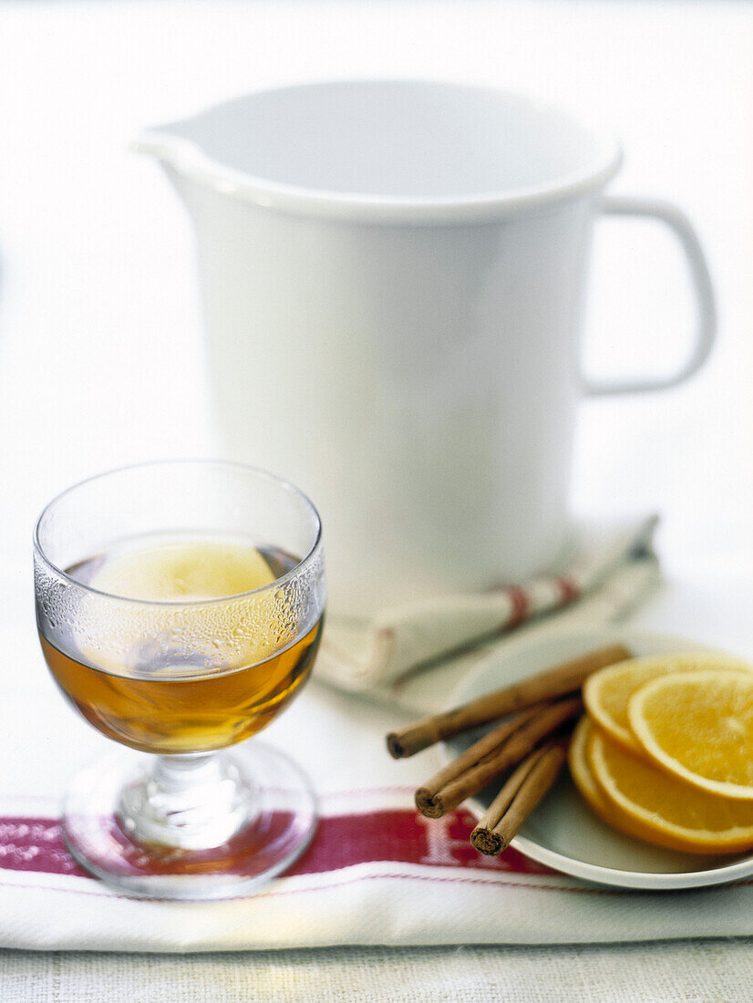 Glas Tee mit Zimtstangen und Orangenscheiben