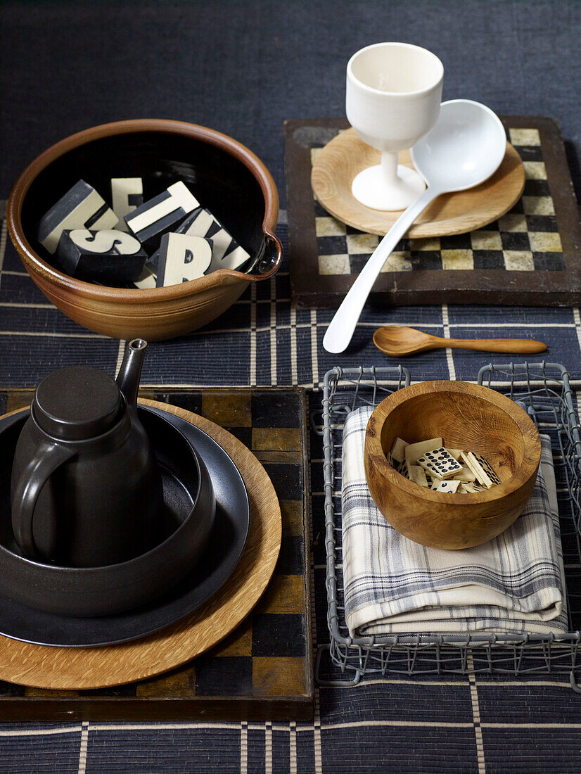 Assorted letters in bowl with monochrome crockery and dominos