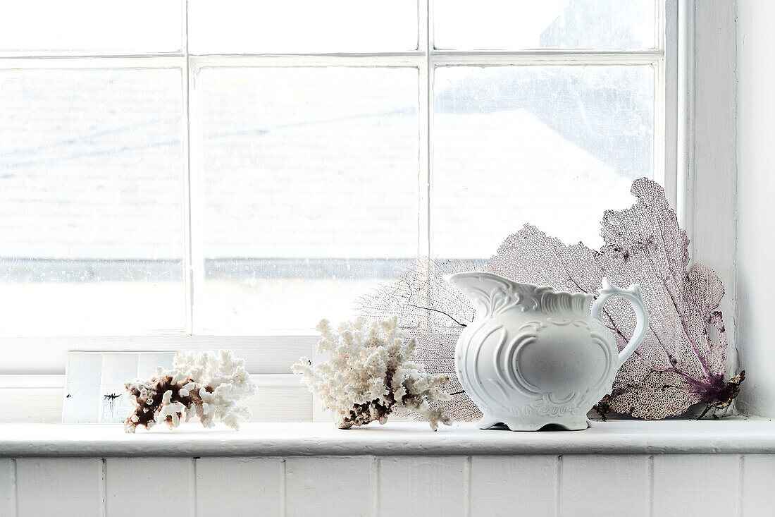 Ceramic jug and coral on windowsill in Lyme Regis home Dorset UK