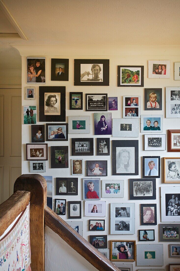 Extensive display of family photographs on staircase in Cranbrook home, Kent, England, UK