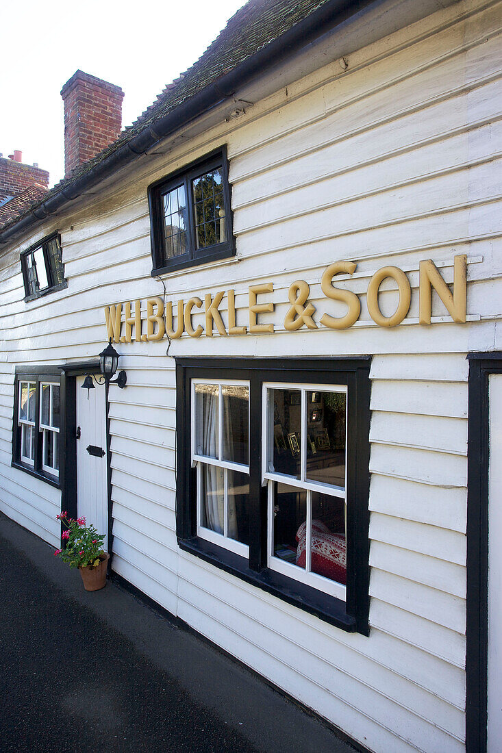 Weißes Schindelhaus mit schwarzem Anstrich und Schriftzug in Egerton, Kent, England, UK