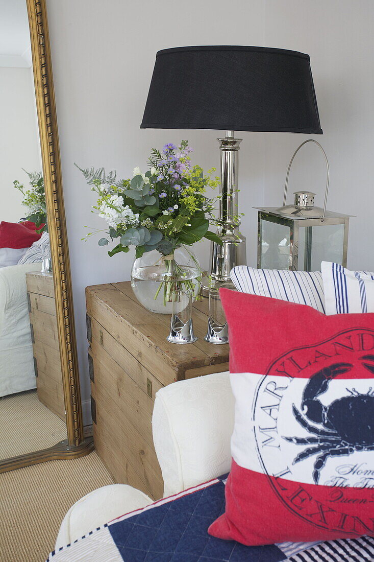 Black lampshade with cut flowers on crate in living room of Dartmouth home, Devon, UK