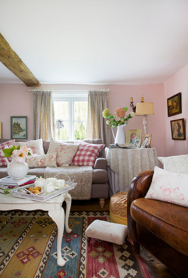 Gingham-Karierte Kissen mit Teetablett im Wohnzimmer eines Bauernhauses in High Halden (Kent, England)