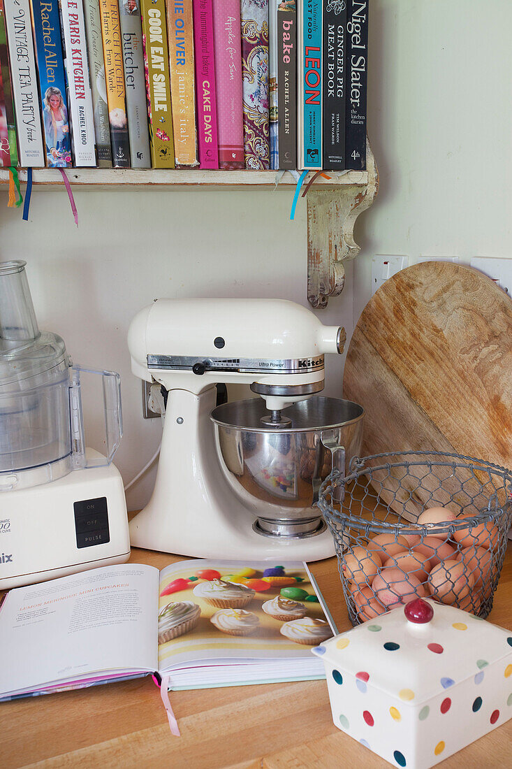 Foot mixers and recipe books with chopping board on kitchen worktop in High Halden farmhouse Kent England UK