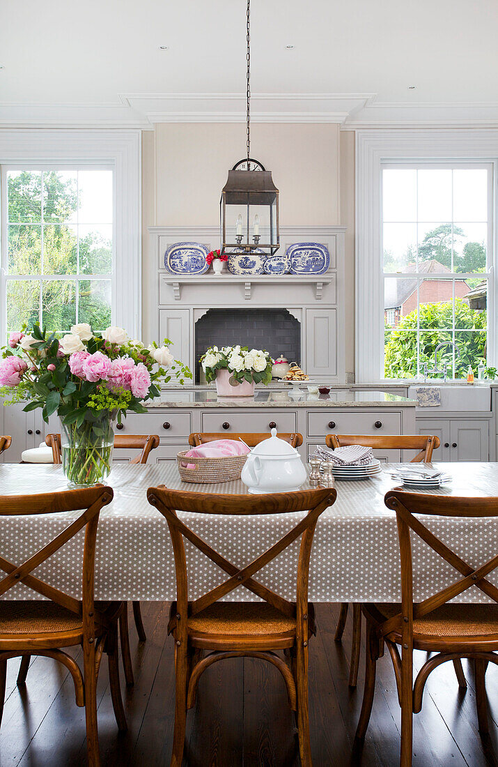 Wooden chairs at dining table with spotted tablecloth in Kilndown home Cranbrook Kent England UK