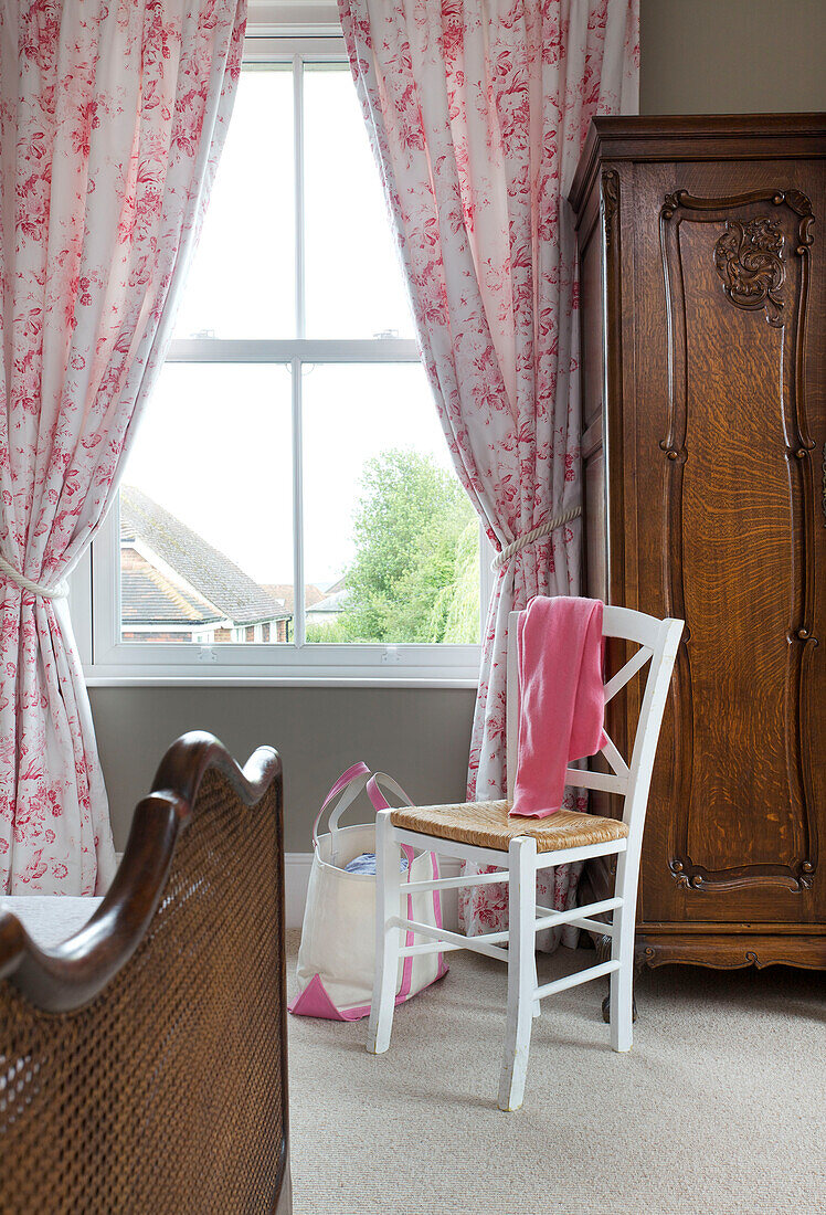 Up-cycled chair with antique wardrobe at window in Kilndown bedroom Cranbrook Kent England UK