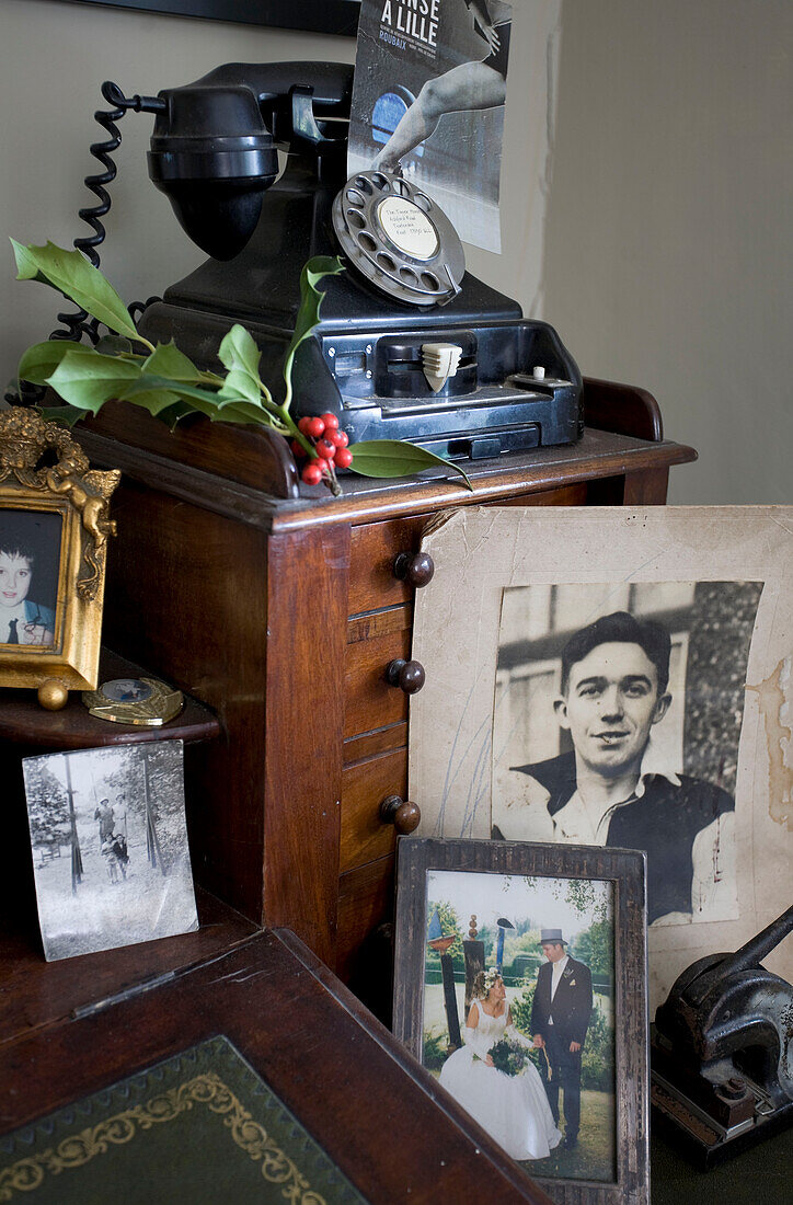 Familienfotos und Wählscheibentelefon in einem Haus in Tenterden, Kent, England, Vereinigtes Königreich