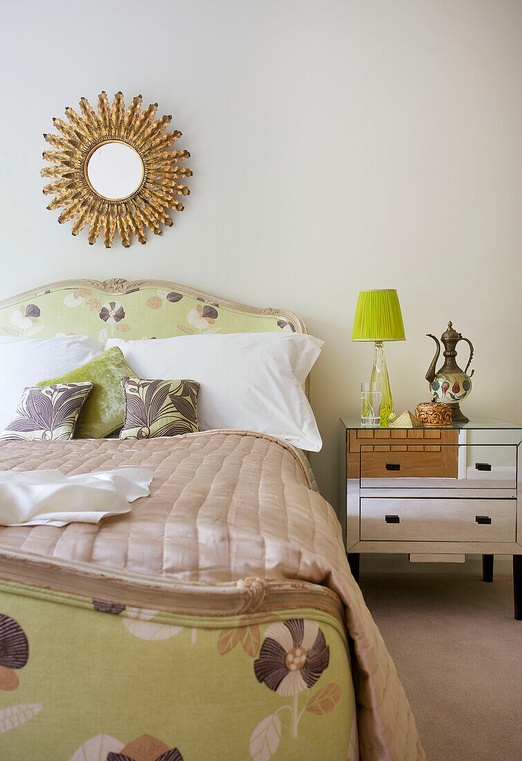 Vintage mirror above double bed with mirrored bedside cabinet in modern home Bath Somerset, England, UK